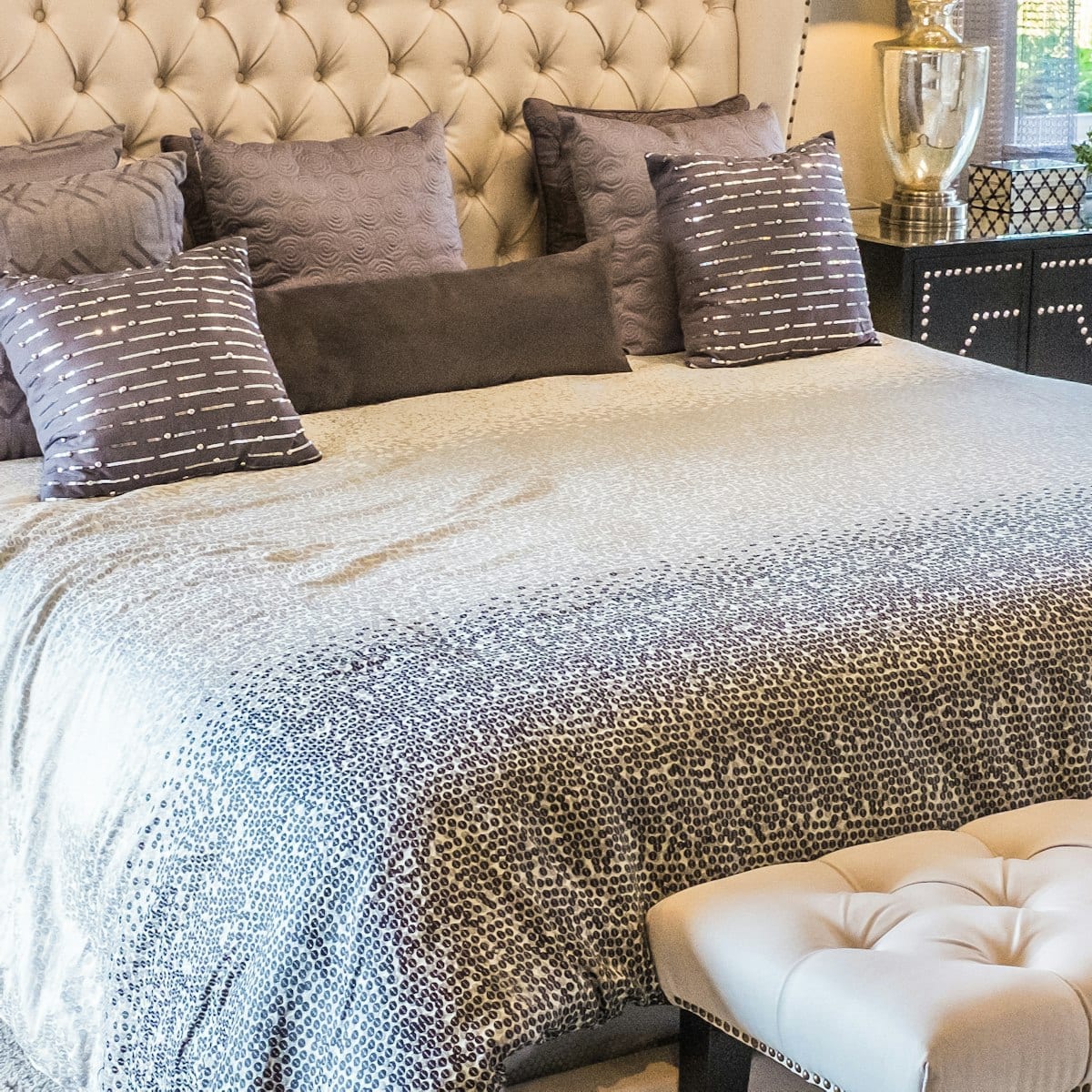 Detalhe do capitonê da cabeceira e das almofadas sobre a cama
